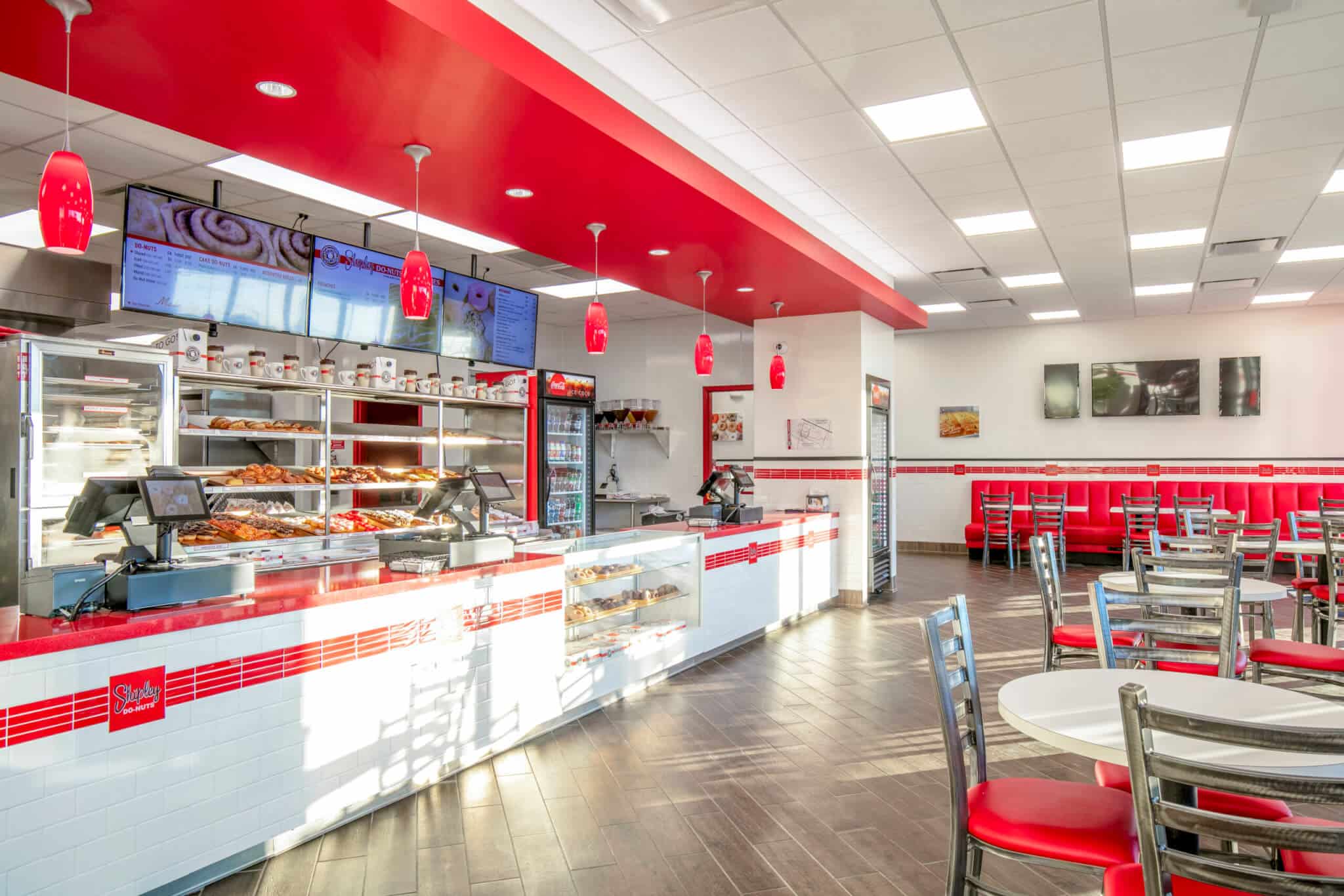 A red and white donut franchise restaurant with tables and chairs